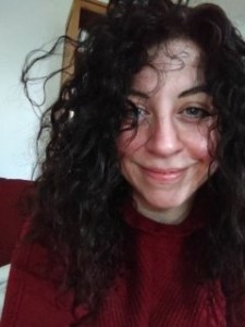 Selfie of Justine smiling, with dark hair